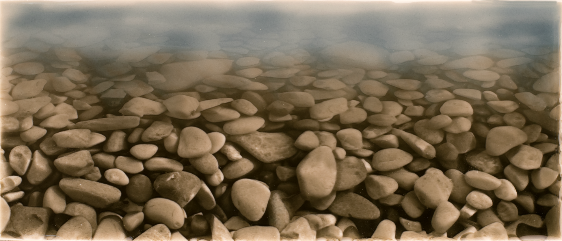 Ceramic pebble wall tile design featuring smooth, rounded pebbles in earthy tones, ideal for enhancing shower wall aesthetics.