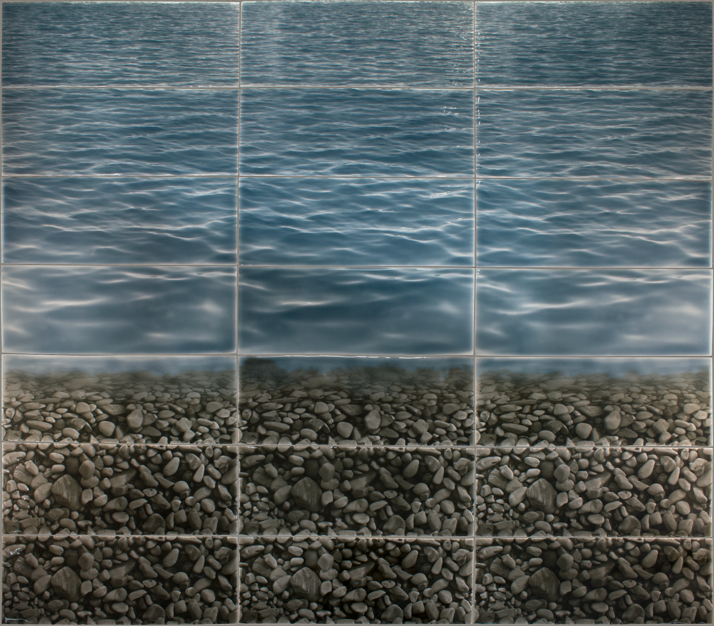 Tile mural featuring a realistic design of a serene water surface above a textured pebble shoreline, ideal for enhancing shower wall aesthetics.
