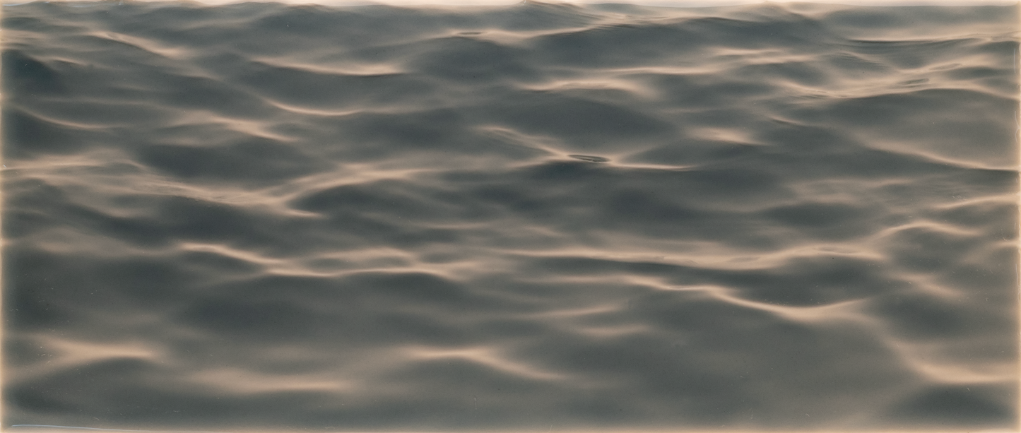 Textured tile mural design resembling gentle water waves, ideal for enhancing shower wall aesthetics with a calming ambiance.