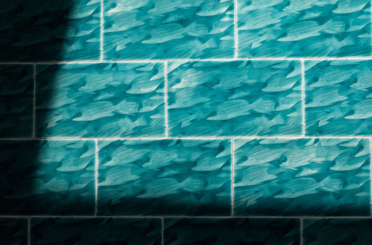 Coastal-themed tile featuring a pattern of swimming fish in shades of teal, ideal for enhancing bathroom decor with a tropical aesthetic.