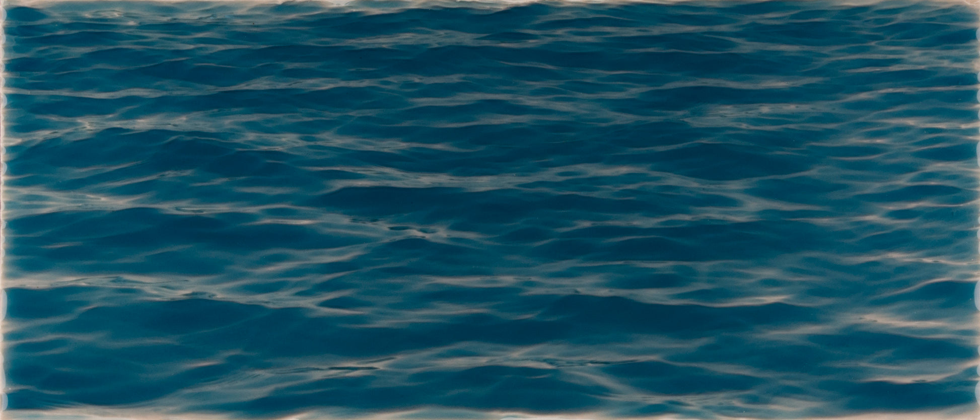 Deep blue water surface with gentle ripples, evoking a beach-themed atmosphere for bathroom decor.