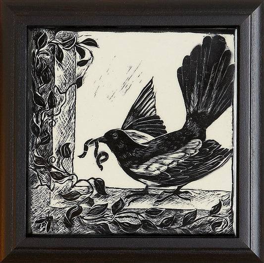 Black and white woodcut tile featuring a bird with a curled vine in its beak, framed by decorative leaves, part of Living Walls Tile's art collection.