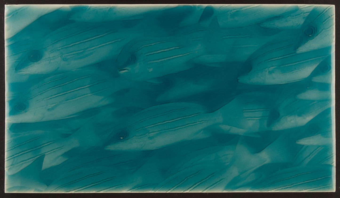 Artisan tile featuring a design of little fish in a turquoise ocean-inspired background, ideal for coastal bathroom decor.