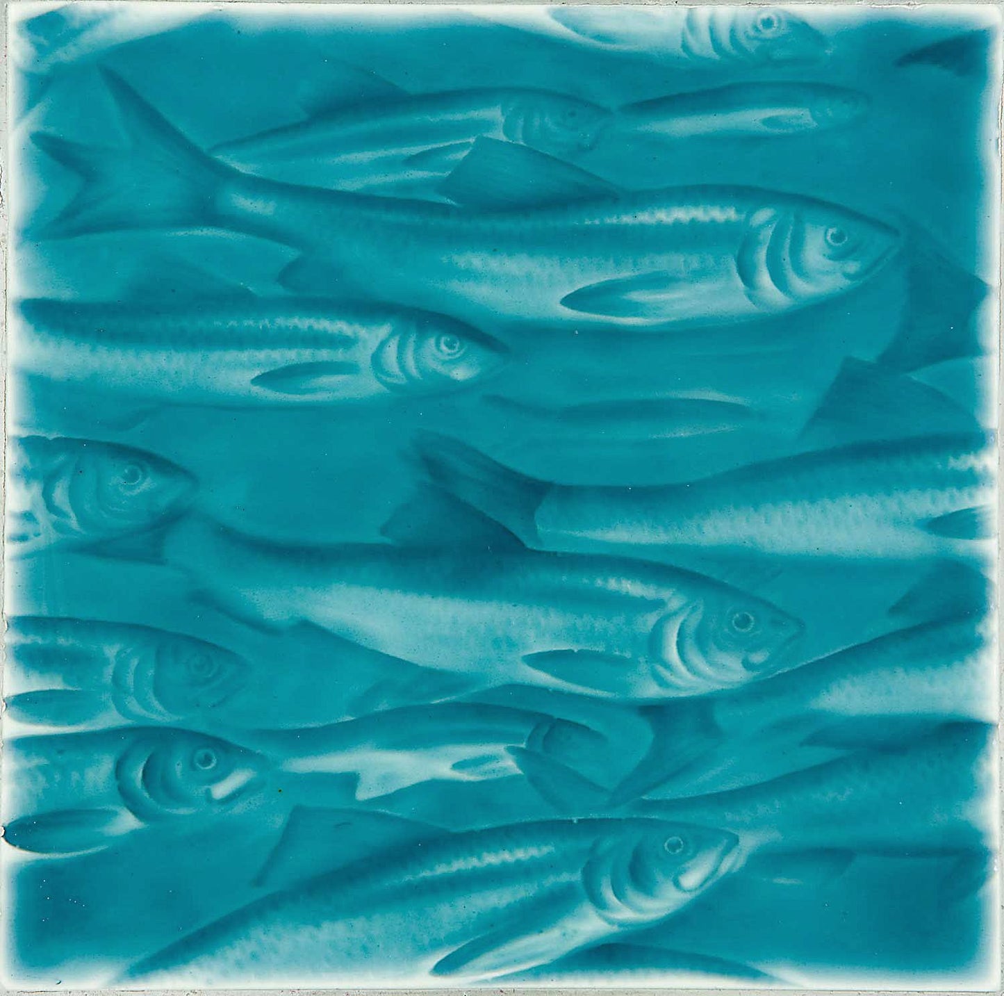 Artisan tile featuring a design of swimming fish in ocean-inspired turquoise hues, ideal for coastal bathroom decor.