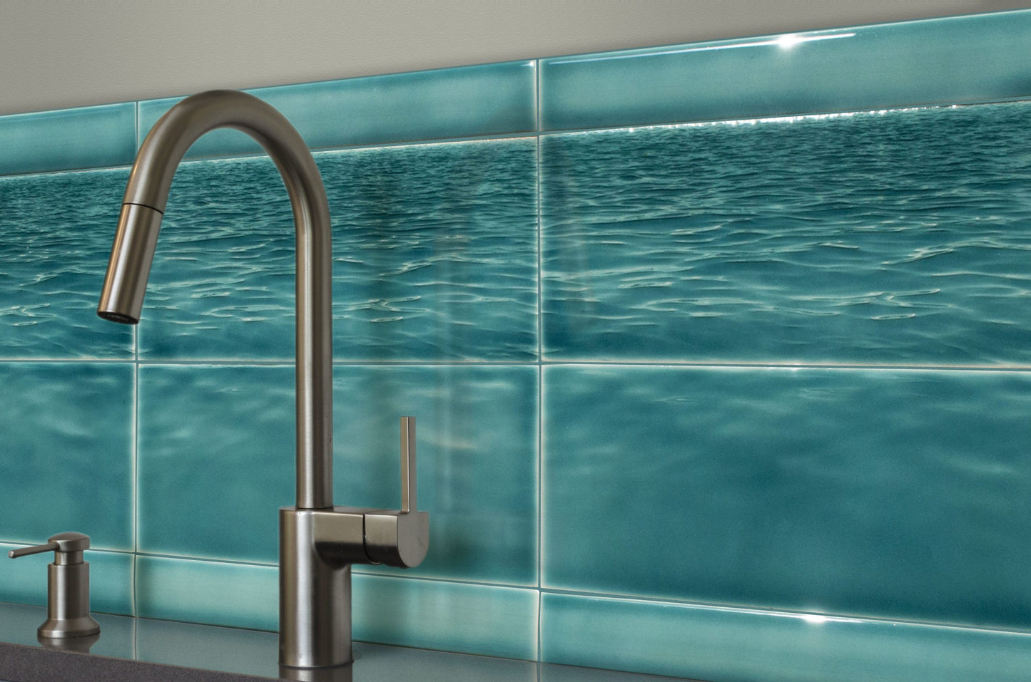 Ocean water backsplash tile mural featuring a modern faucet, enhancing beach-themed bathroom decor.