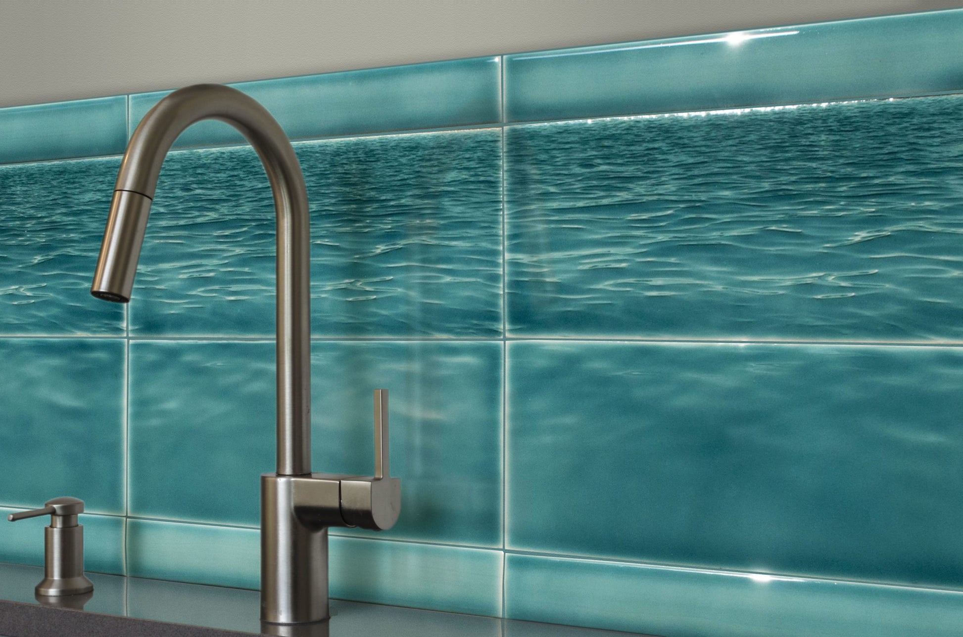 Ocean water backsplash tile mural featuring a modern faucet, enhancing beach-themed bathroom decor.