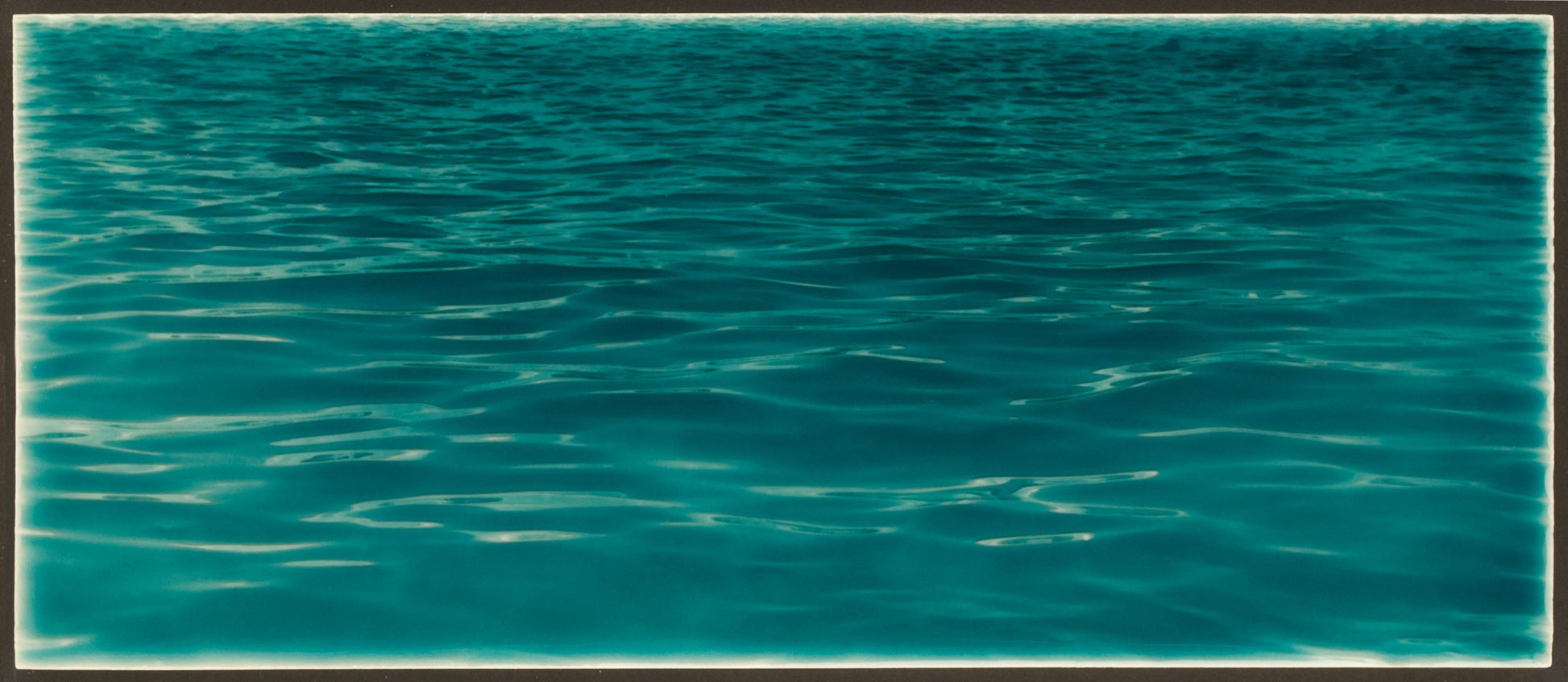 Tranquil ocean water surface with gentle ripples, ideal for beach-themed bathroom backsplash inspiration from Living Walls Tile.