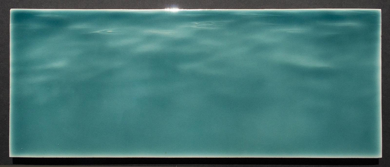 Tranquil ocean water-inspired backsplash tile in teal, perfect for beach-themed bathroom decor.